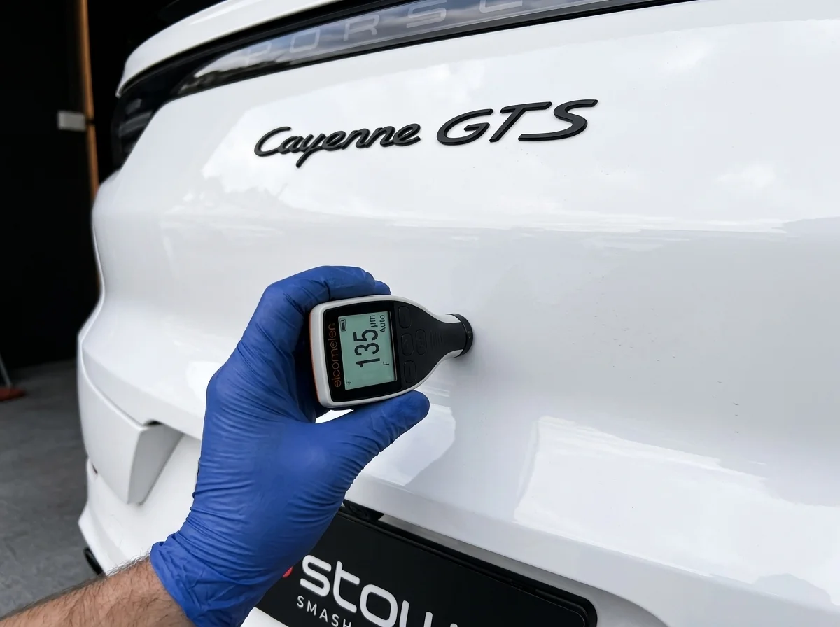 Detailer measuring clear coat thickness using a digital gauge at Stow Smash Repairs